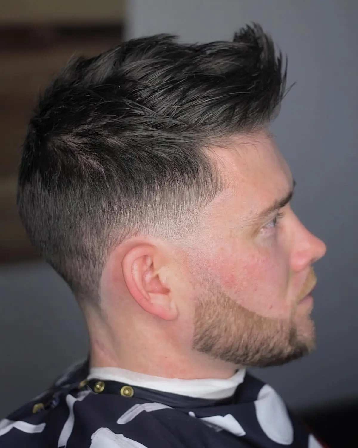 A layered men's haircut with a textured, high-volume quiff.