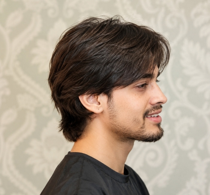 Layered straight haircut for men with light texture, subtle flicked ends, and fuller shape on top
