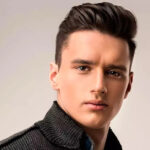 A stylish man with a modern textured quiff haircut and a skin fade, showcasing height and volume.