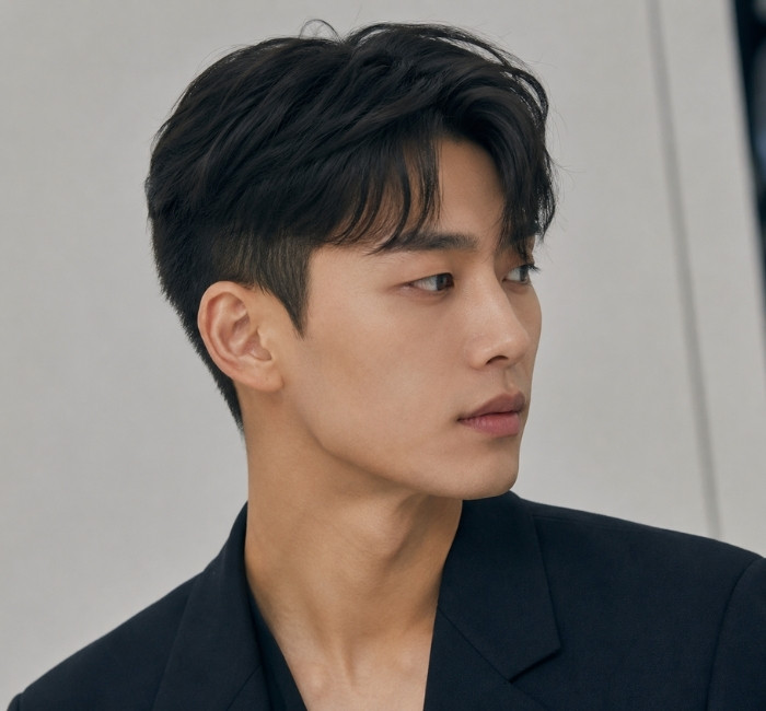 Fictional East Asian man with a modern two block haircut and softly textured longer top.