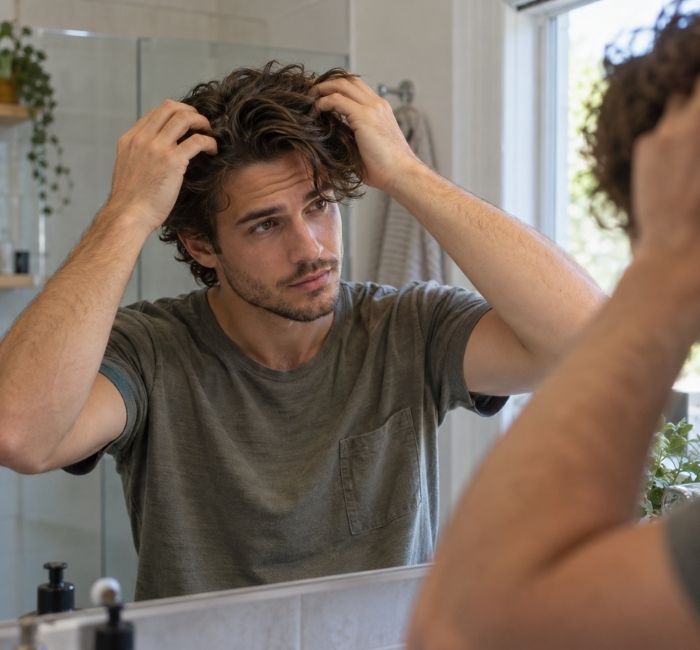 Man styling naturally wavy hair