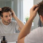 Man styling hair with wax